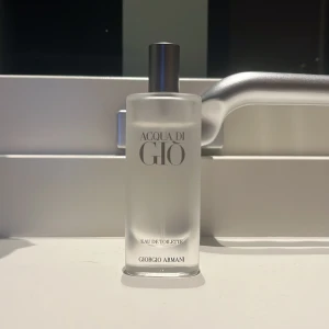 Acqua di Giò Eau de Toilette - Säljer en elegant och fräsch Acqua di Giò Eau de Toilette från Giorgio Armani. Flaskan är stilren och genomskinlig med en silverfärgad kork. Perfekt för om man vill ha en uppfriskande doft. 13/15 ml 