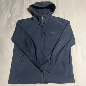 Mörkblå zip ifrån Hugo boss  - Säljer en  mörkblå zip hoodie från Hugo boss. Använder den inte längre då den är lite stor för mig. Storlek M och inga defekter så i bra skick. Skriv vid frågor eller funderingar 