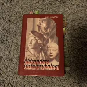 Åldrandets socialpsykologi - Boken 'Åldrandets socialpsykologi' av Lars Tornstam utforskar de sociala och psykologiska aspekterna av åldrande. Den har en röd framsida med en bild av klassiska skulpturer och är utgiven av Norstedts. Perfekt för den som studerar eller är intresserad av socialpsykologi.