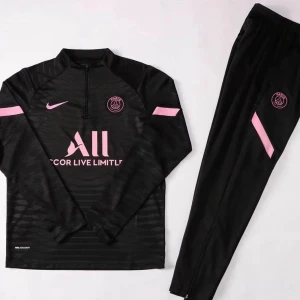 Psg tracksuit - Snygg svart träningströja från Nike med rosa detaljer och PSG-logga. Tröjan har en halv dragkedja och långa ärmar, perfekt för fotbollsträning. Den har även ett diskret mönster och texten 'COR LIVE LIMITLESS' på framsidan.