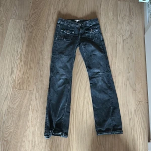 Svarta bootcut jeans - Snygga svarta bootcut jeans med låg midja och klassisk femficksdesign. Perfekta för en avslappnad stil. De har en dragkedja och knapp framtill.