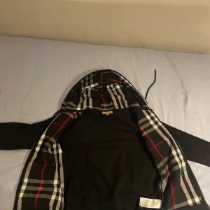 Svart hoodie från Burberry - Säljer en stilren svart hoodie/kofta från burrberry. Den är storlek S och bra passform. Använd max 15 gånger. Skön kofta allmänt och bra skick. Pris kan diskuteras privat.