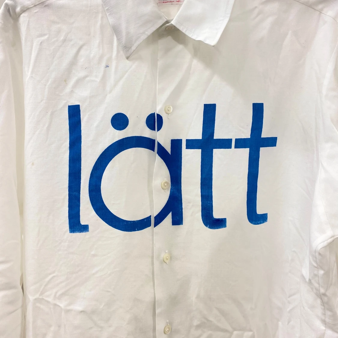 Vit skjorta med blå text - 1