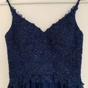 Marinblå balklänning - Superfin marinblå balklänning från Mascara i storlek 34. Länk til klänningen: https://www.zalando.se/mascara-festklaenning-navy-m0921c0e9-k11.html  Se bild för mått på klänningen, passade perfekt på mig som är 166cm med klackar. Klänningens full-längd är 144cm. Köpt på Plick för 800kr men den var tyvärr för liten för mig. Därmed endast använd en gång av förra ägaren och är som ny. Hör av dig vid frågor💕