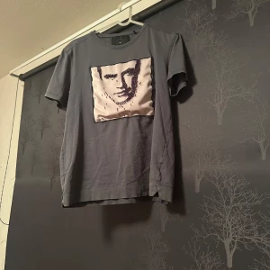 Grå t-shirt från Limitato - Snygg grå t-shirt från Limitato med ett unikt ansiktsmotiv på framsidan. Storleken är S och priset är inte hugget i sten. Skriv vid minsta fråga!