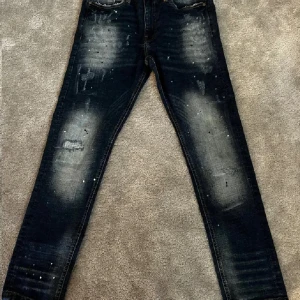 Svarta jeans med slitningar - Snygga svarta jeans med coola slitningar och en tvättad look. De har en klassisk femficksdesign och en straight passform. Perfekta för en avslappnad stil.