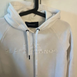 Vit hoddie  - Vit hoddie från peakperformance, storlek S. Knappt använd så väldigt gott skick.