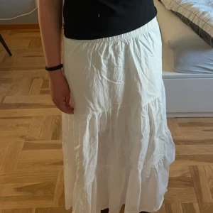 Vit långkjol - Söt vit långkjol med volangdetaljer och resår i midjan. Den är i storlek 146 🩷