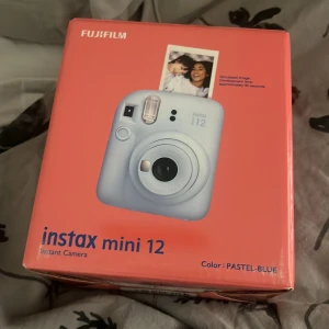 instax mini 12 - Detta är inte en bok, utan en instax mini 12 instantkamera i färgen pastel-blue. Perfekt för att fånga ögonblick och skriva ut bilder direkt – kul för fester, resor och kreativa projekt!