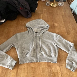 Grå croppad hoodie från SHEIN - Grå hoddie från SHEIN, storlek S. Små fläckar som fotades på bilderna, tunt material och kort.