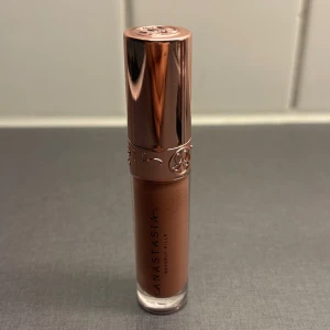 Anastasia Lipgloss Deep Taupe - Snyggt läppglans från Anastasia Beverly Hills i färgen Deep Taupe. Ger en glossig finish med en varm, brun taupe-nyans som passar perfekt till en naturlig look.