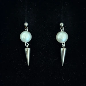 Silvriga örhängen med pärlor och spikes - Handgjorda och unika silverörhängen 🤩 Öronhängerna är nickelfria och silverpläterade i kirurgiskt stål, resterande av örhänget är i rostfritt stål (ej silverpläterat) 💕🙏 3.5 cm långa. Alla köp görs via ”KÖP NU” knappen.  💐