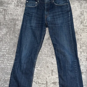 Levi's 752 blå jeans W32 L34 - Säljer ett par klassiska Levi's 752 jeans i mörkblå denim. Snygga kontrastsömmar och ikonisk läderpatch bak i midjan med fyra fickor. Perfekta för dig som gillar tidlös stil och vill ha ett par jeans som funkar till allt. Fint skick, knappt använda. Pris kan diskuteras. Hör av er för fler bilder om det behövs.