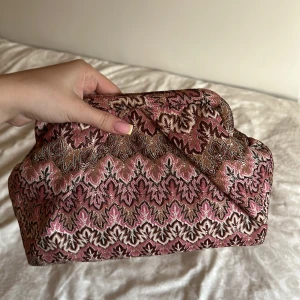Mönstrad väska från Becksöndergaard - Intressekoll på min unika väska från Becksöndergaard med broderat mönster i rosa, brunt och beige. Väskan har en mjuk form, innerficka med dragkedja och är tillverkad i textilmaterial. Perfekt för dig som vill sticka ut med en cool accessoar.