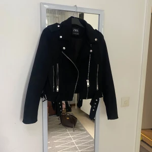 Bikerjacka- Zara - Bikerjacka från Zara i nyskick, endast använd 1 gånger. Stilrent mocka material, storlek M. Säljes pga fel storlek. Inköpt för 599 kr.
