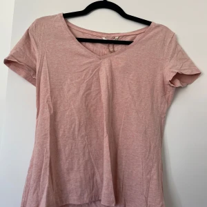 Ljusrosa v-ringad topp i bomull - Enkel och snygg ljusrosa topp med v-ringning och korta ärmar.