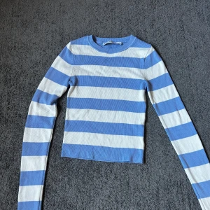 Blåvit randig tröja från Bershka - Superfin långärmad tröja från Bershka i blått och vitt med breda ränder. Tröjan är ribbad och har en tight passform med rund halsringning. Har en superliten fläck på baksidan av ärmen (se sista bilden)💞