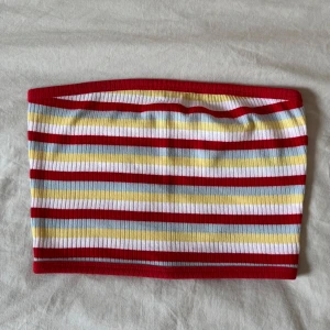 Randig tubtopp  - Tubtopp eller bandeau med ribbad struktur och färgglada ränder i rött, vitt, gult och ljusblått. Jättefint skick!
