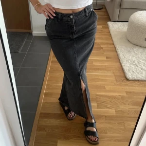 Lång jeanskjol  - Svart/grå lång jeanskjol med slits från nakd. Helt ny, oanvänd med prislapp kvar! 