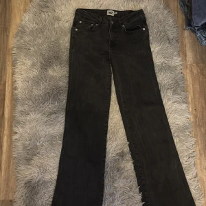 Svarta bootcut jeans 157 90s Boot - Svarta jeans från 157 i modellen 90s Boot med bootcut-ben och klassiska femficksdetaljer. Jeansen har snygga bakfickor med lock och knapp, samt en något kortare längd. Perfekta för dig som gillar retrovibbar och stilren look.