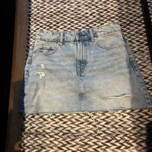 Ljusblå jeanskjol från Stradivarius - Ljusblå jeanskjol från Stradivarius. Kjolen är kort med rå, fransig fåll och slitna detaljer framtill. 🩷🩷 Köpte på Vinted förra året och har använt några få gånger 🩷