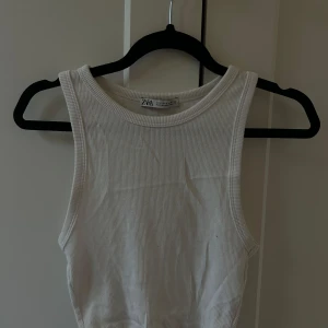 Vitt ribbat linne från Zara - Säljer en vit ribbad linnetopp från Zara i storlek S. Toppen är ärmlös med rund halsringning och har en tight passform. 🤍🤍