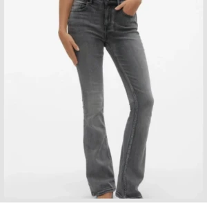 Grå VM-flash jeans med slitningar - .Säljer ett par grå  jeans med snygga slitningar vid knäna. Jeansen har klassisk femficksdesign, hög midja och är tillverkade i mjukt denimtyg. Perfekta för dig som gillar en avslappnad men trendig look.