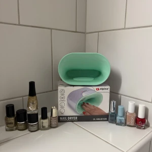Nagellack och nageltork från Alpina - Säljer ett kit med nageltork från Alpina i mintgrönt och flera nagellack i olika färger: guld, silver, beige, blått, rött och nude. Märken som Essie, Mavala, Golden Rose, Depend och fler. Perfekt för dig som vill fixa snygga naglar hemma med både metallic och klassiska nyanser. 