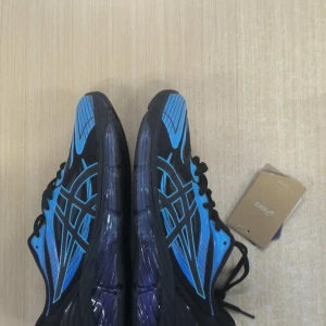 ASICS GEL-Quantum 360 blå/svarta sneakers - ASICS GEL-Quantum 360 sneakers i svart och blått med coola detaljer och genomskinlig sula. Skorna har snörning och sportig vibe, perfekt för dig som gillar att sticka ut. Ovandelen är i syntet och mesh för bra andningsförmåga.MÖTS UPP ENDAST I GÖTEBORG EJ FRAKT!