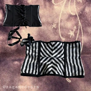 Randig snörkorsett från Boux Avenue - Säljer en svartvit randig korsettväst från Boux Avenue med snörning baktill. Den har coola grafiska ränder och är tillverkad i glansig polyester med elastan för stretch. Perfekt för att skapa en edgy look med en croppad passform.