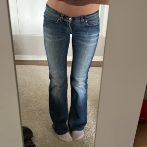 Blå bootcut jeans från only - Säljer ett par blå bootcut jeans från only med snygg slitning och klassiska bakfickor. Jeansen har låg midja och är tillverkade i mjukt denimtyg med stretch. Perfekta för dig som gillar en avslappnad men ändå trendig look.