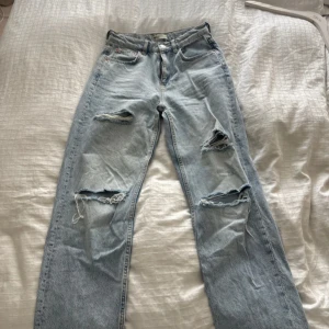 Ljusblå håliga jeans - Säljer ett par ljusblå jeans från Gina i rak modell med snygga slitningar och hål på båda benen. Hög midja och raka ben. 