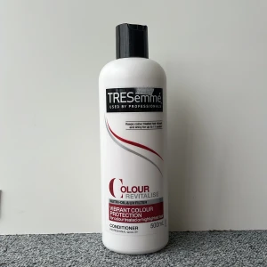 TRESemmé Colour Revitalise balsam 500ml - TRESemmé Colour Revitalise balsam med UV-filter och Nutri-Oil, speciellt för färgat eller slingat hår. Stor vit plastflaska med svart snäpplock, röd och silverdetaljer. Ger färgskydd och glans, professionell kvalitet. 500 ml. Säljer både schampoo och balsam.