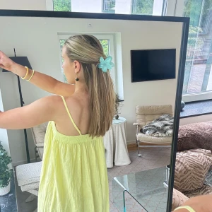 Ljusgul långklänning med tunna axelband - Superfin ljusgul långklänning med tunna axelband och flowy passform. Klänningen har en luftig och somrig känsla, perfekt för varma dagar. Materialet är lätt och faller snyggt. Enkel och stilren design som känns fräsch och trendig.