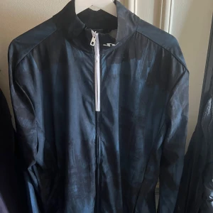 J lindeberg jacka - Denna dubbelfärgade tunna jacka är menad för golf men den är så stilren att jag använt den till vardags. Storlek L. 