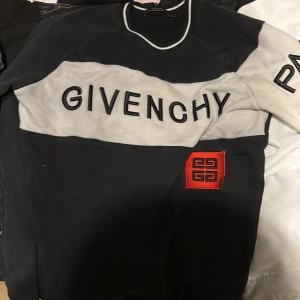 Givenchy  sweatshirt - Snygg svart och grå sweatshirt från Givenchy med stor logga framtill och röd broderad detalj. Tröjan har rund halsringning med vit kant och långa ärmar. Perfekt för dig som vill sticka ut med en exklusiv streetstyle-look.