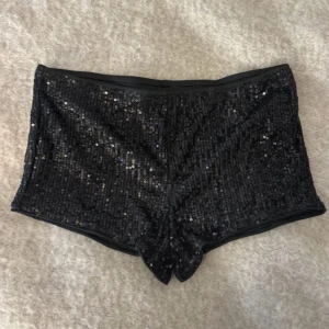 Svarta paljettshorts - Snygga svarta shorts täckta med glittrande paljetter, lågmidjade. Aldrig använda😊
