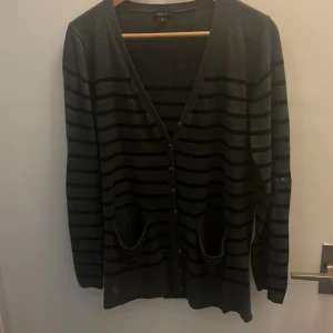 Svart randig kofta från Lindex - Svart kofta från Lindex i storlek S med horisontella ränder och knäppning framtill. Koftan har två fickor och långa ärmar. Perfekt för lager-på-lager och chill stil. Materialet känns mjukt och lätt, passar bra till jeans eller kjol.💕💕