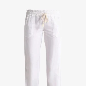 Vita linnebyxor med snörning - Snygga vita linnebyxor med avslappnad passform och elastisk midja med snörning. Byxorna har raka ben, fickor fram och bak samt är perfekta för en chill och luftig stil. Passar grymt till sommaren och ger en fräsch vibe.