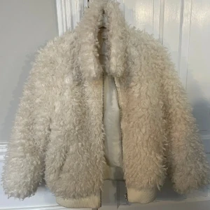 Vit teddyjacka med dragkedja - Supermysig vit teddyjacka från H&M som inte går att köpa längre🤍Perfekt för dig som vill ha en varm och trendig jacka nu i höst/vinter. Endast använd max 4 gånger så i nyskick❤️Skriv för flera bilder!