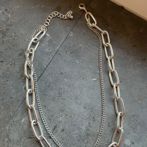Silver halsband - Ett silverfärgat kedjehalsband. Helt ny skick, har bara använt två gånger. Den har inte tappat färg men tror inte det är äkta silver. Halsbandet har justerbar längd. Pris kan diskuteras🙏