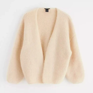 Beige stickad kofta från Lindex - Supermjuk och fluffig beige stickad kofta från Lindex i öppen modell. Koftan har breda ärmar och en avslappnad passform. tyvärr för stor på mig 💛 
