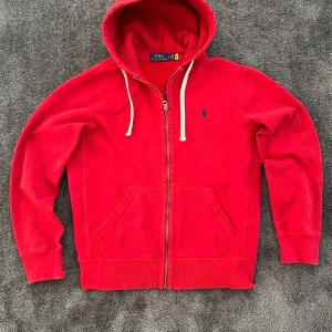 Polo Ralph Lauren zip hoodie - Röd Ralph Lauren zip-up hoodie – stl 170/XS Snygg och klassisk röd hoodie från Ralph Lauren med hel dragkedja och luva. Passar ungefär storlek XS eller 170 i barnstorlek. Skön passform och perfekt till vardags! Fint skick. Finns även certifikat på sista bilden