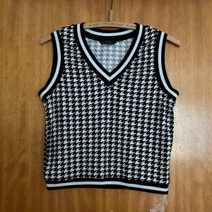 Svartvit väst med hundtandsmönster - Väst från SHEIN i svart och vitt med klassiskt hundtandsmönster. Västen har v-ringning och ribbade kanter i svart och vitt. Markerad som XS men skulle mer säga S-M då den är väldigt oversized!❤️