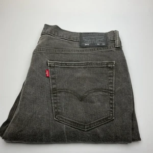 Levi's 541 grå jeans  - Snygga grå Levi's 541 jeans med klassisk femficksdesign och rakt snitt. Jeansen har en cool tvättad look och är tillverkade i slitstarkt denim. Perfekta för dig som gillar en avslappnad men ändå stilren vibe.