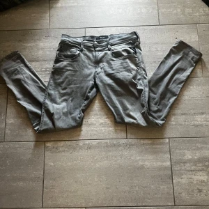 Grå Replay jeans  - Snygga grå jeans från Replay  Jeansen har en stilren look med diskreta detaljer och är tillverkade i mjukt jeansmaterial som sitter skönt hela dagen. Perfekta för dig som gillar en clean och modern stil. Slim fit.