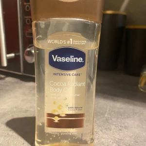 Vaseline Cocoa Radiant Body Oil 200ml - Vaseline Intensive Care Cocoa Radiant Body Oil med ren kakaosmör och återfuktande oljor. Perfekt för att ge huden glow och mjukhet. Innehåller 100% naturligt kakaosmör och är lätt att applicera. Har använts vid bara 2 tillfällen💕