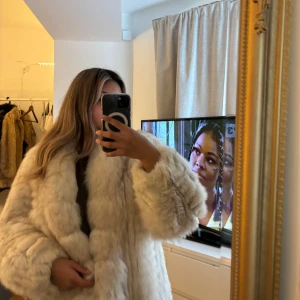Beige fluffig pälsjacka - Intressekoll på min beige pälsjacka med bred krage och långa ärmar. Jackan är gjord av blå räv. Den har en riktigt fluffig look och är perfekt för dig som vill sticka ut och hålla dig varm. Passar till alla outfits.