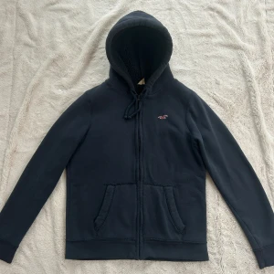 Hollister zip med foder (HERR)  - En zip från Hollister i storlek S. Tröjan bedöms som använd men i fortsatt gott skick. Jag skickar ditt köp inom 24h. Se liknande zip i min profil! G13