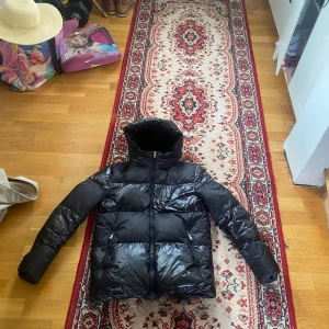 Woolrich jacka  - Svart Woolrich jacka i storlek 14/S. Finns ett lagat hål på ena armen. 3 500kr